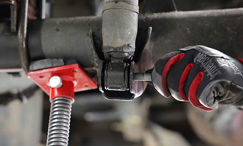 Jemand arbeitet mit einem Schraubenschlüssel an einem Auto.